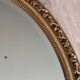 19th century oval gilded mirror, torch & quiver 106cm