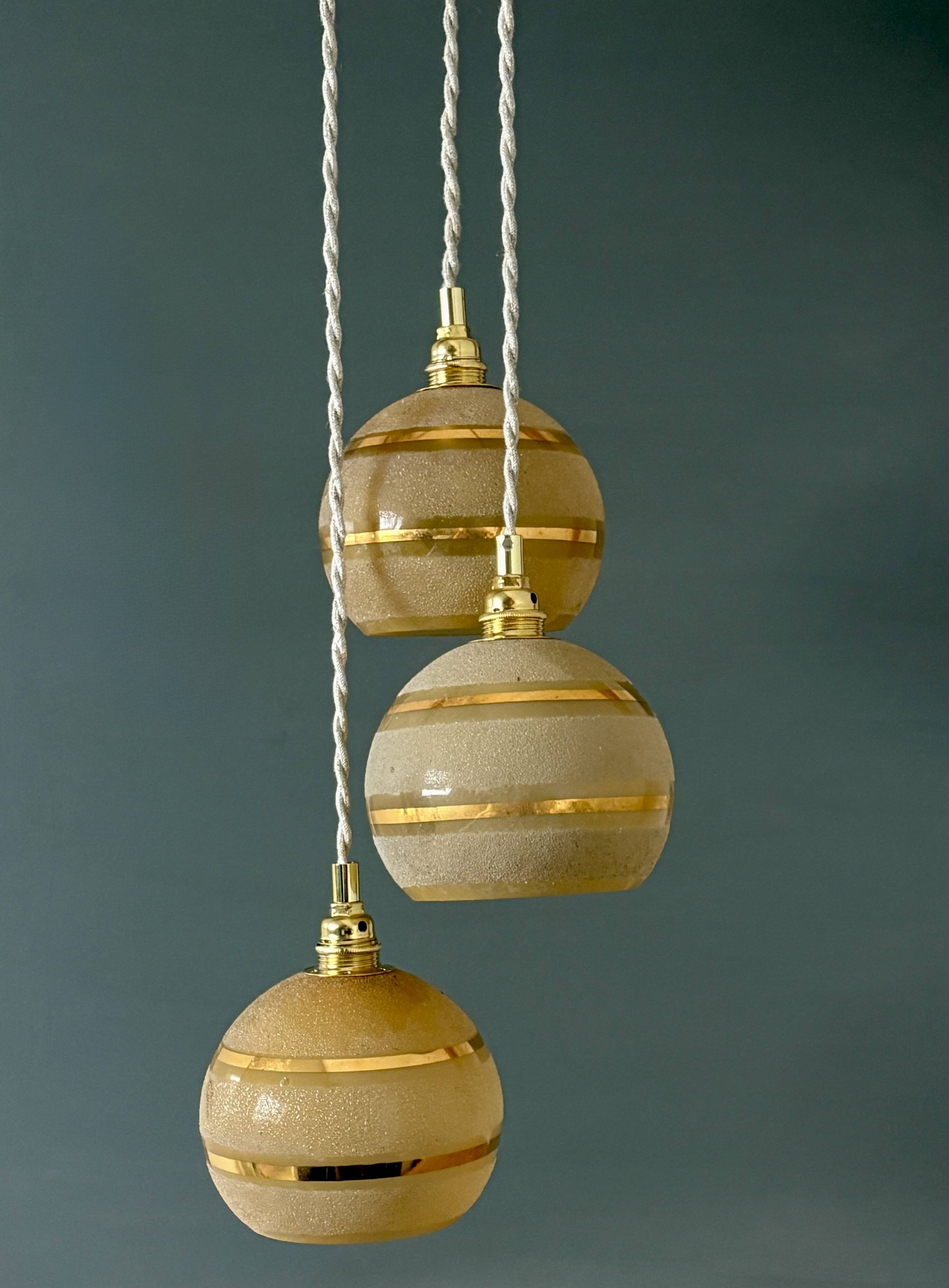Suspension triple vintage glass globes in frosted yellow and gold.