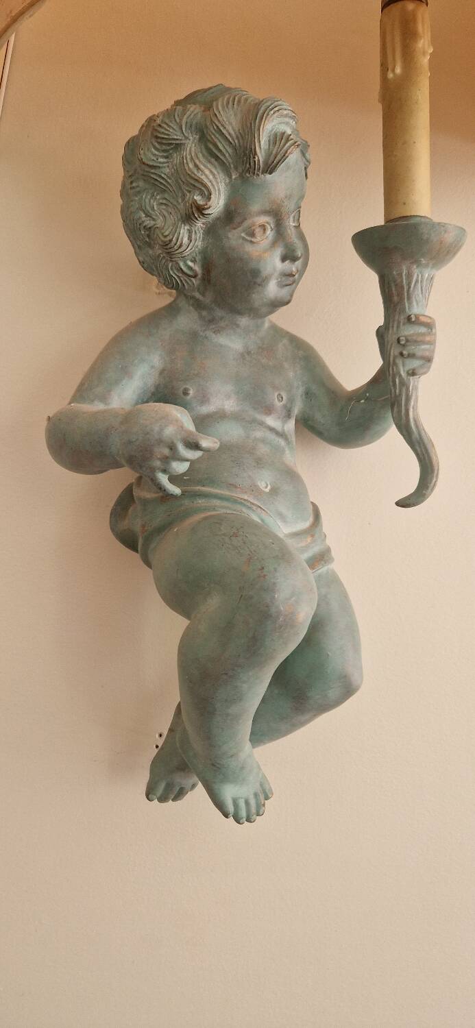 Pairs of wall lights, either two distinct cherubs.