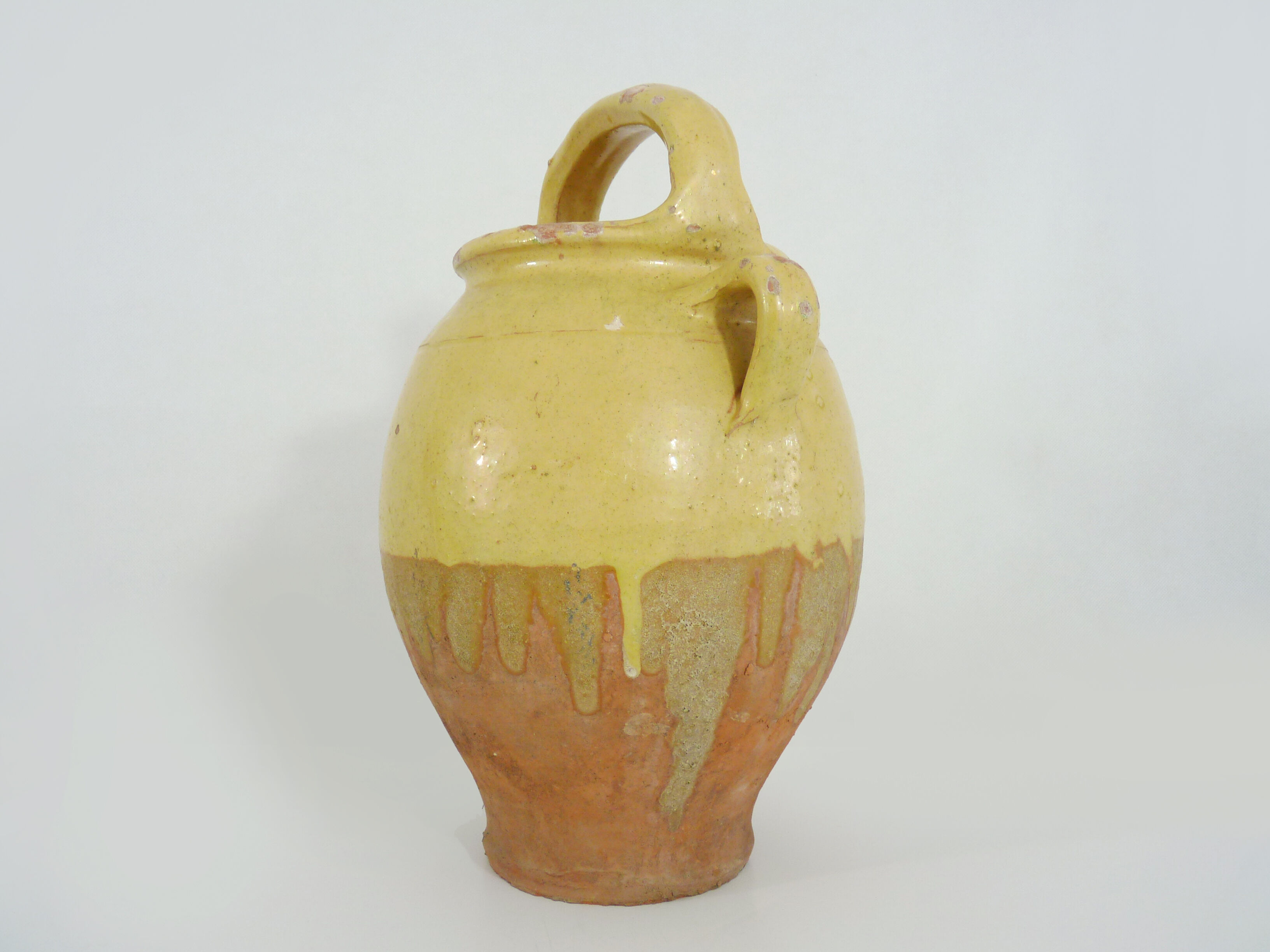 Old jug, chevrette, water pitcher in glazed yellow sandstone. Early twentieth century