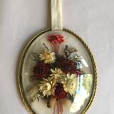 Old medallion frame of dried flowers of oval shape. To hang with velvet stripe.