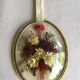 Old medallion frame of dried flowers of oval shape. To hang with velvet stripe.