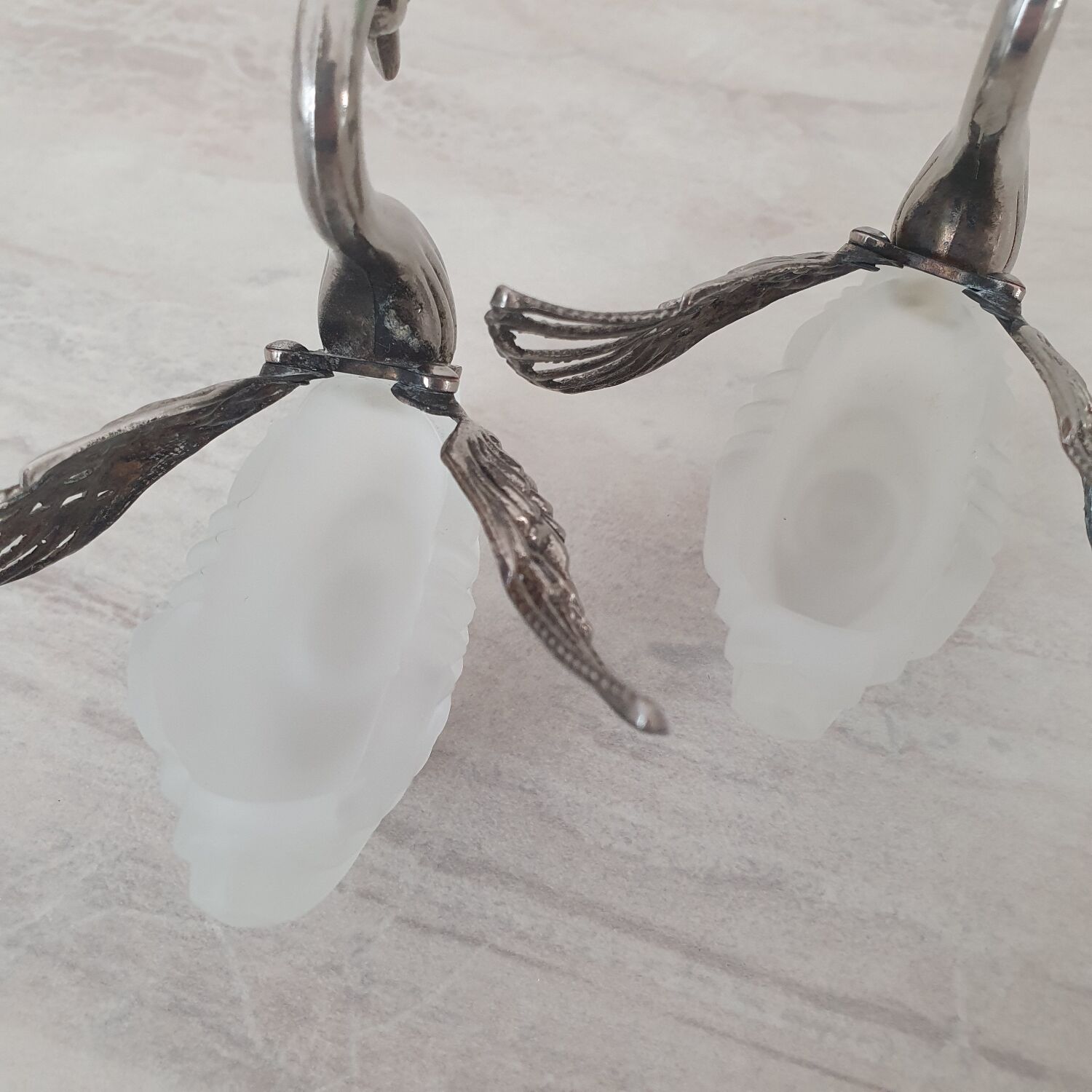 Two frosted glass swan salt cellars with silver plating.