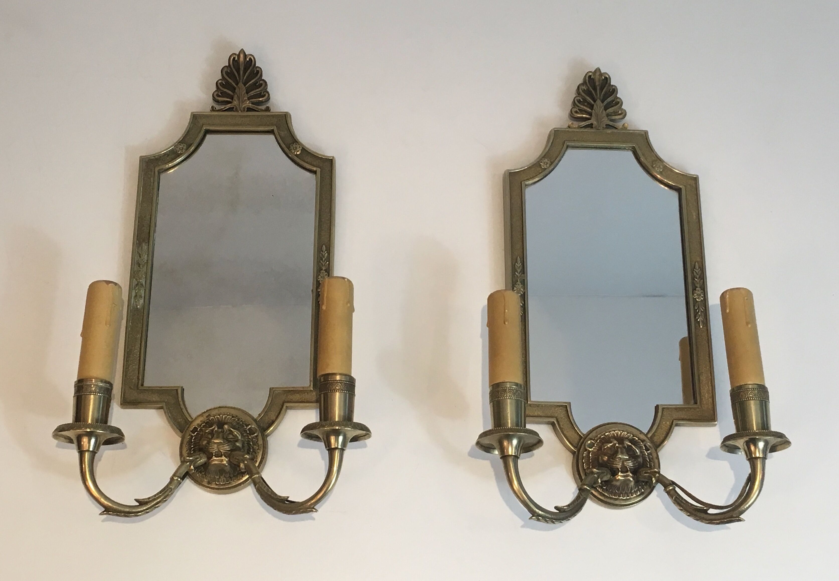 Pair of mirror and bronze wall lamps with lions' heads, french work. around 1940