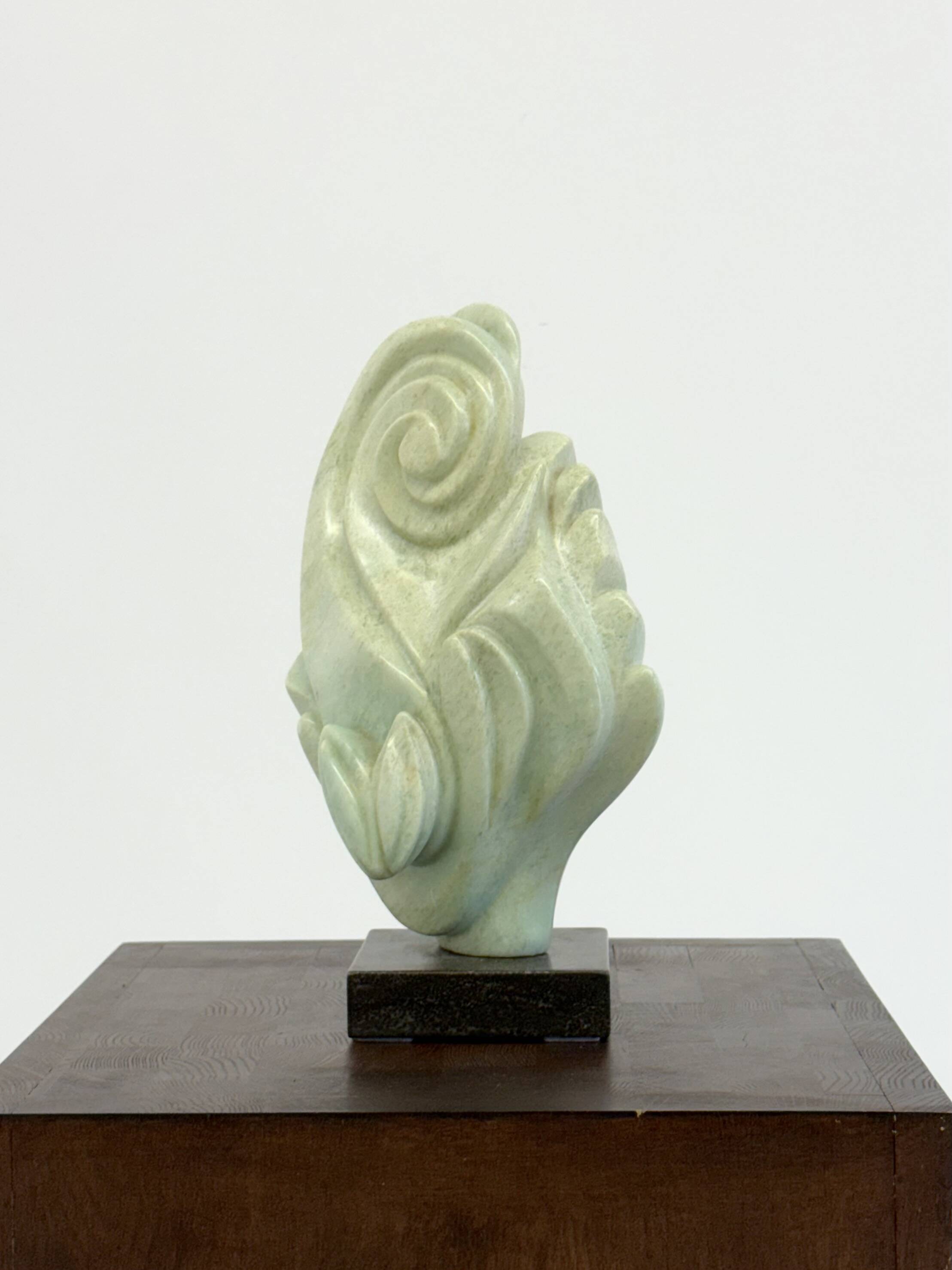 Green natural stone sculpture on marble base