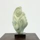 Green natural stone sculpture on marble base