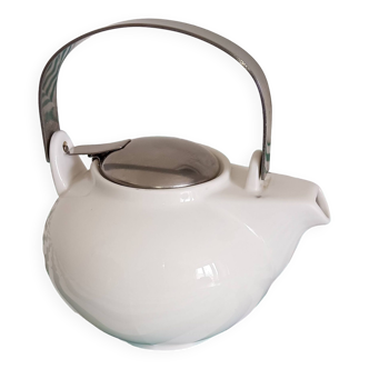 White porcelain teapot. Shiny stainless steel handle and lid