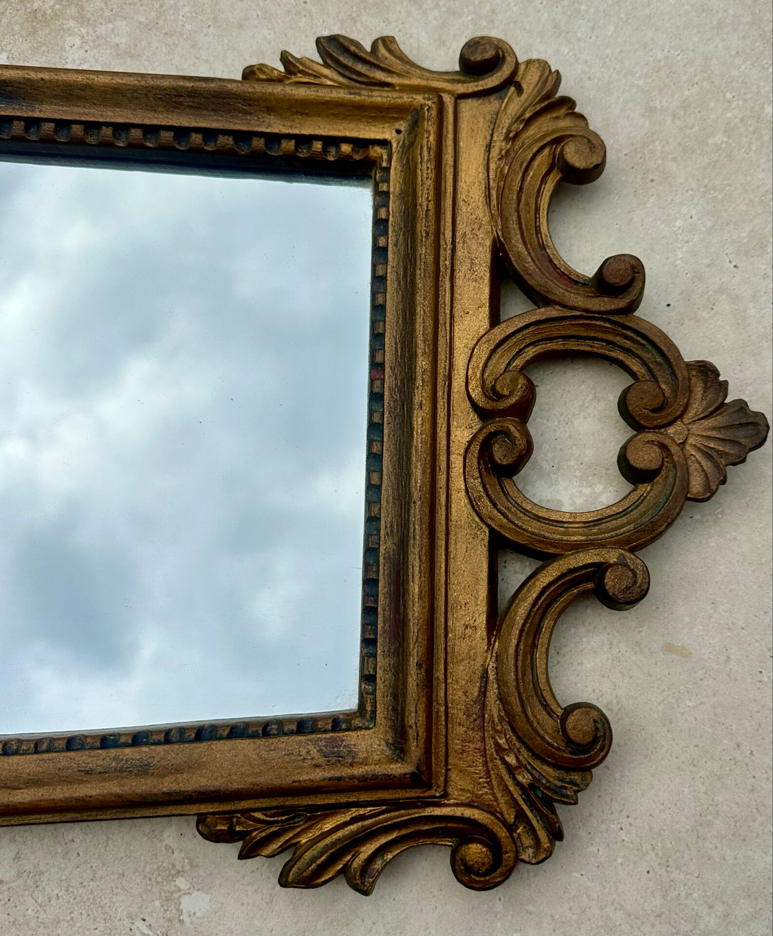 Carved and gilded wooden wall mirror.