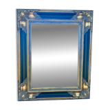 Baroque mirror in gilded wood on a black background.