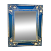 Miroir Baroque en bois doré sur fond noir.