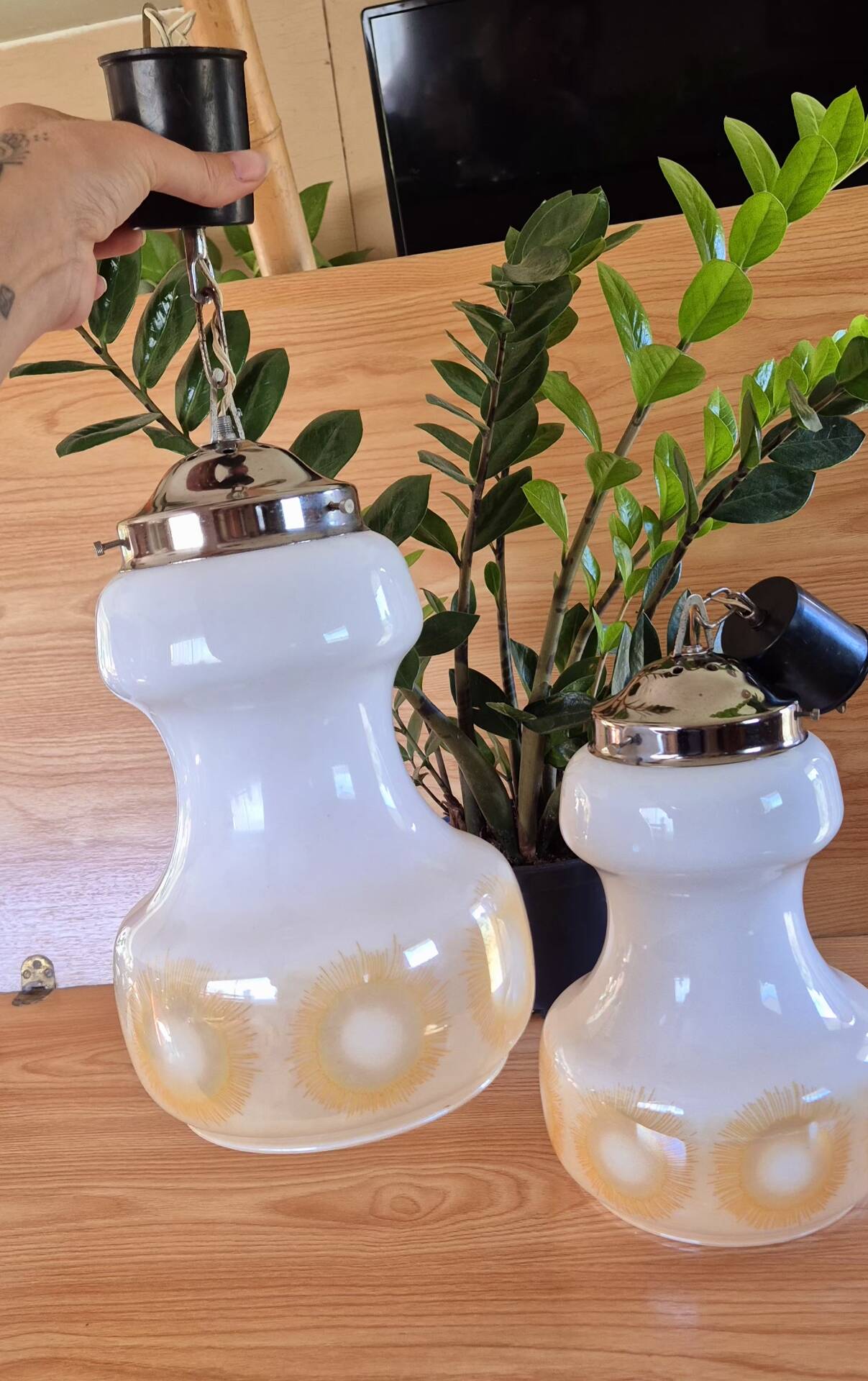 2 vintage pendant lights in white opaline with orange patterns and chrome.