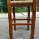 Low stool in brutalist style made of solid wood with straw, 1980.