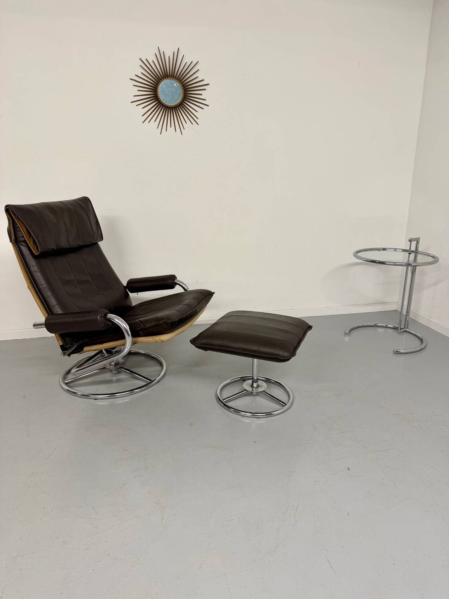 Vintage leather reclining armchair and its 1970s designer ottoman.