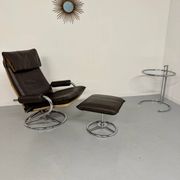 Vintage leather reclining armchair and its 1970s designer ottoman.