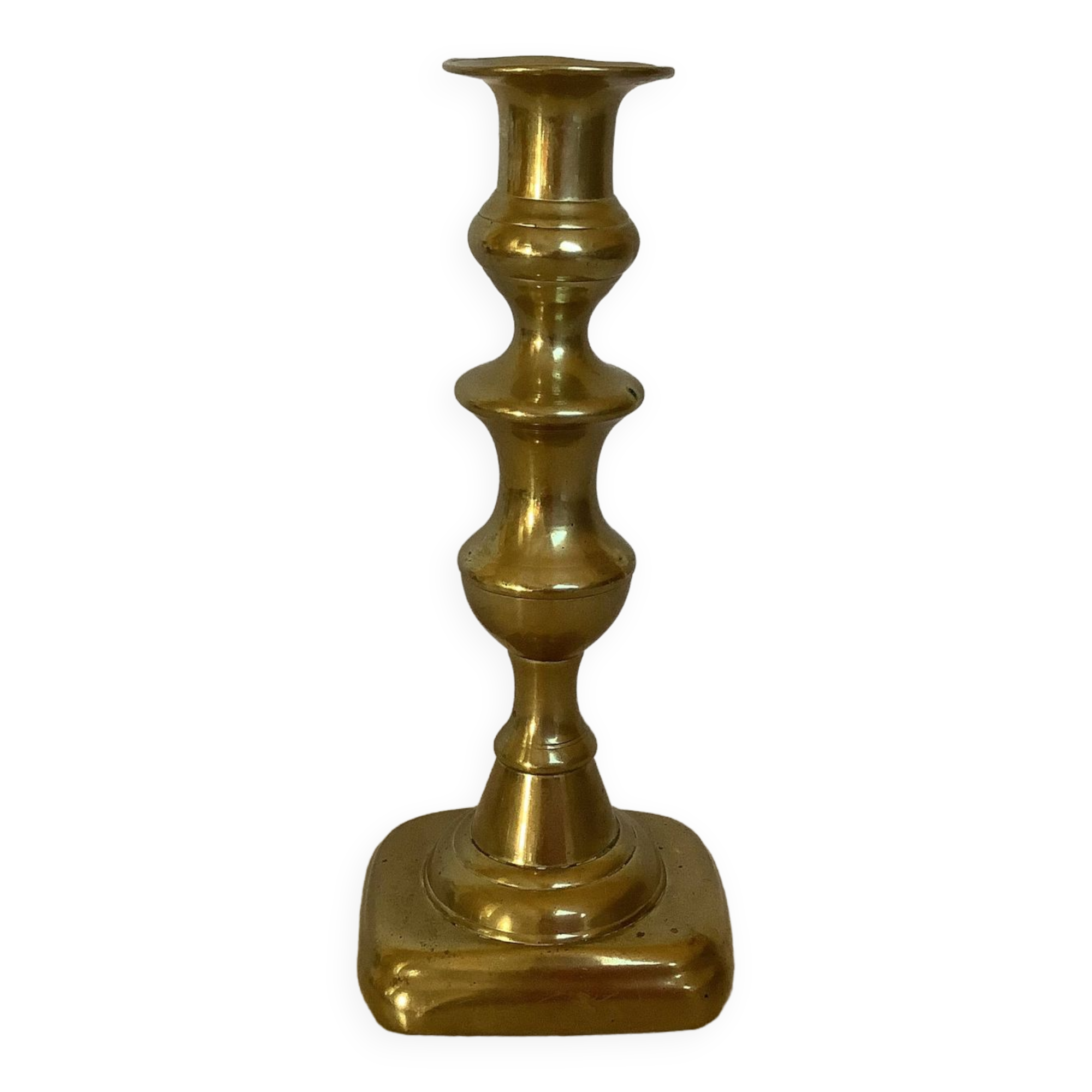 Brass candlestick with a rectangular base.
