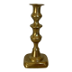 Brass candlestick with a rectangular base.