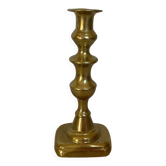 Brass candlestick with a rectangular base.