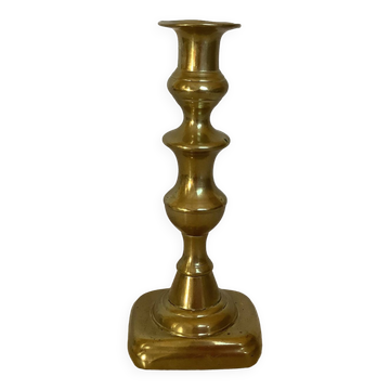 Brass candlestick with a rectangular base.