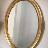 Beveled oval mirror with carved gilded wood frame