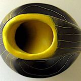 Earthenware vase decorated with yellow lines on a black and yellow background
