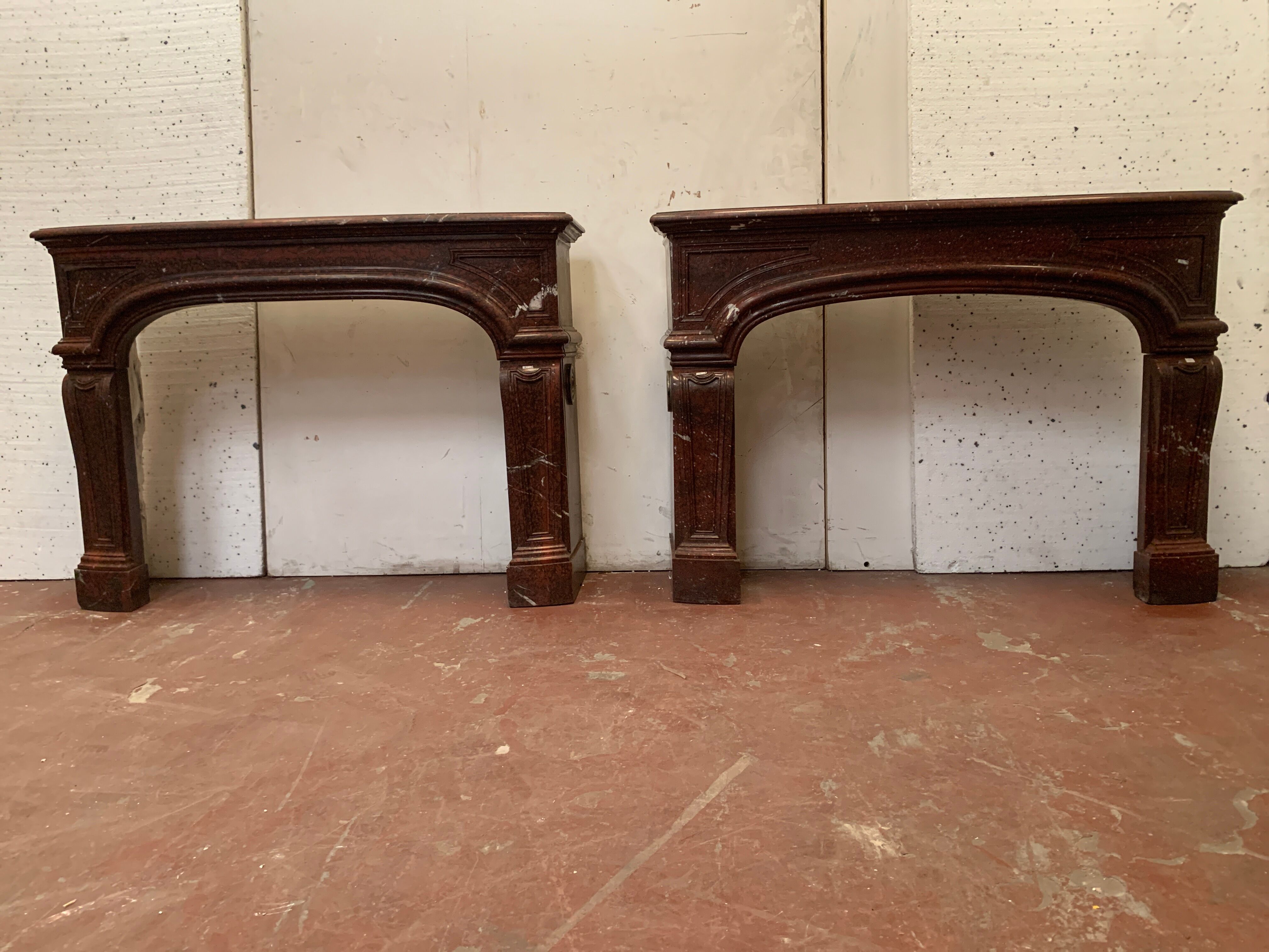 Pair of Louis XIV style fireplaces in red cherry marble. XIX century.