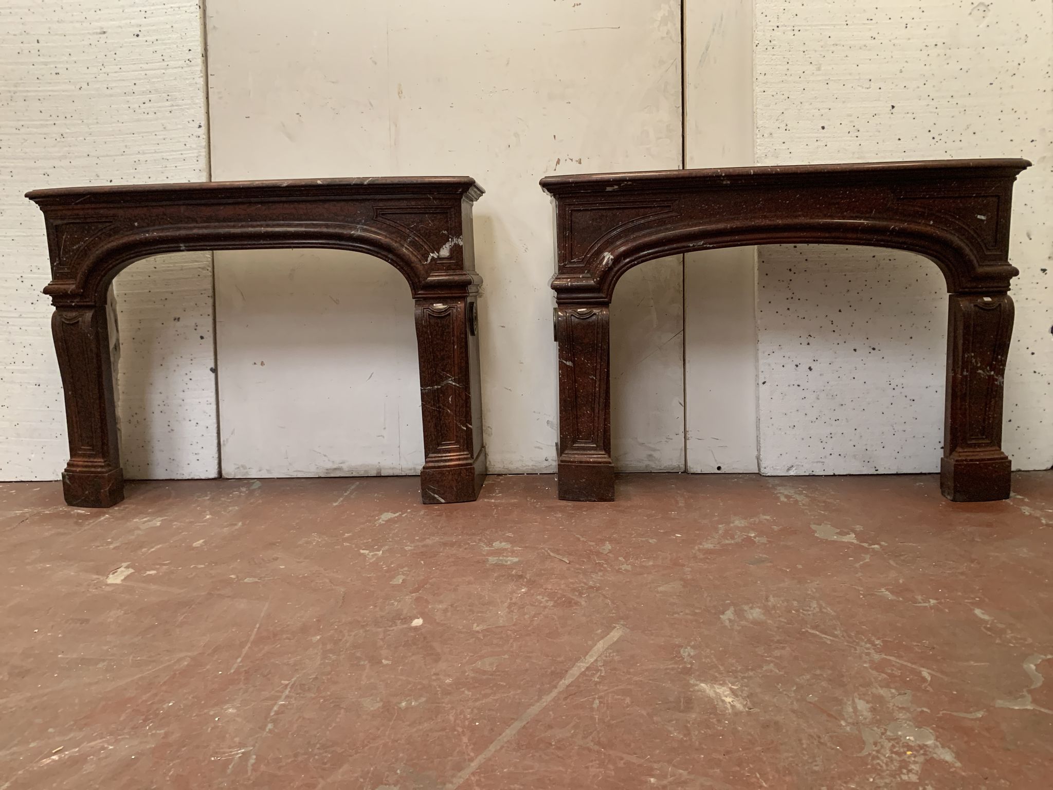 Pair of Louis XIV style fireplaces in red cherry marble. XIX century.
