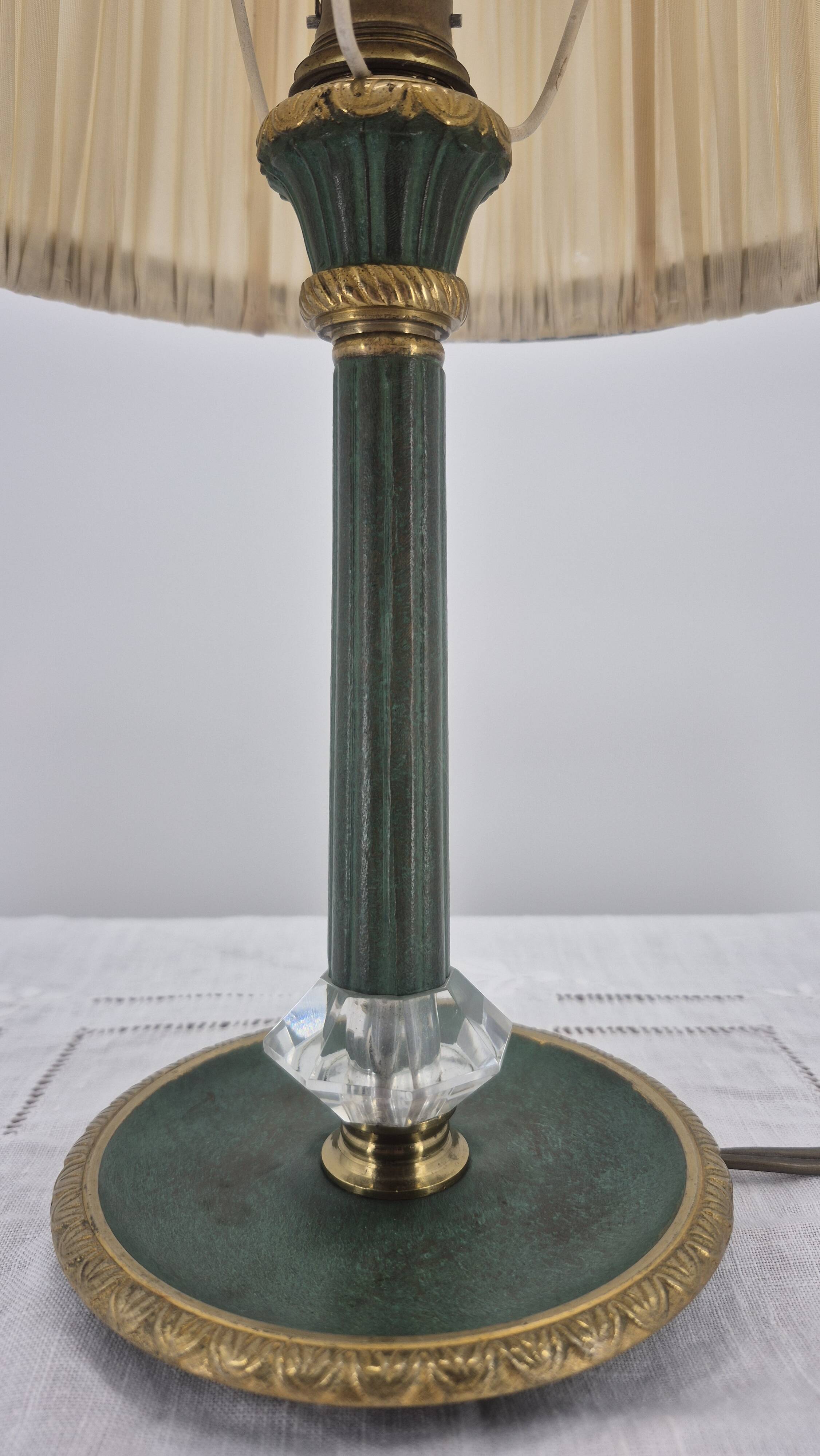 Brass table lamp with green patina and empire-style fabric shade.