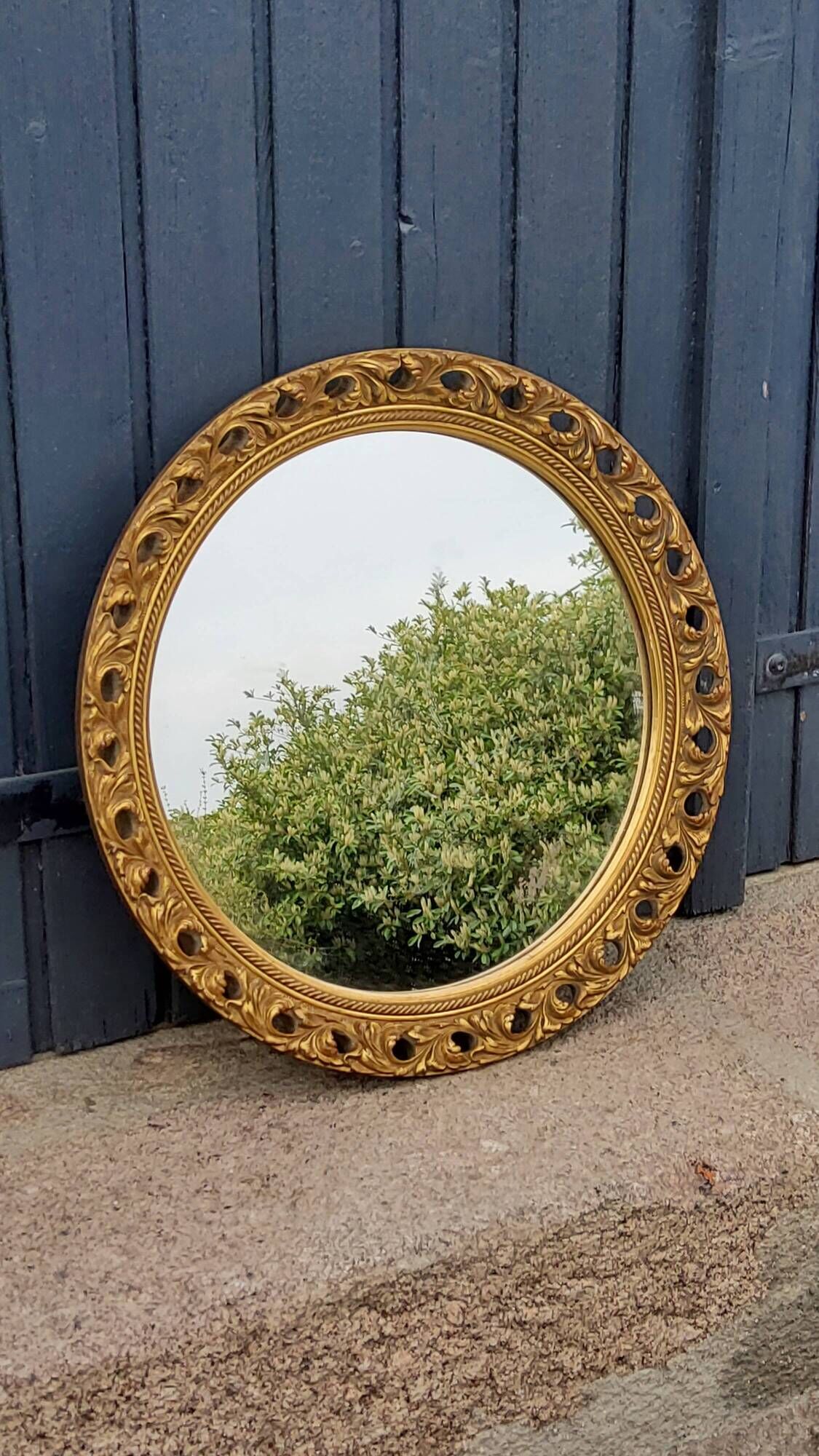 Round neoclassical style mirror in wood and gilded stucco from the 1950s