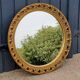 Round neoclassical style mirror in wood and gilded stucco from the 1950s