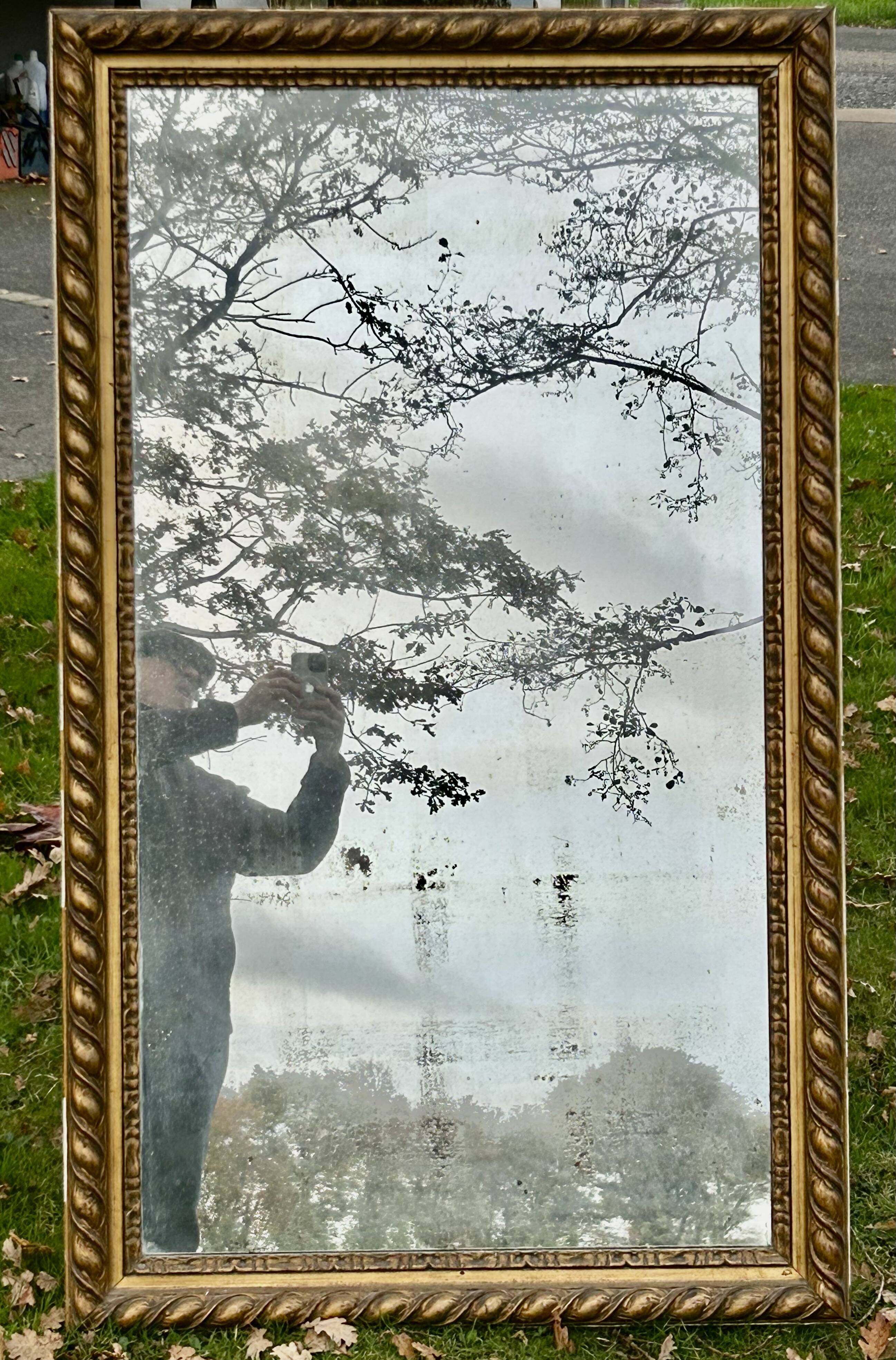 Large antique gilded mirror, wood and stucco gadroons, partially de-mercury