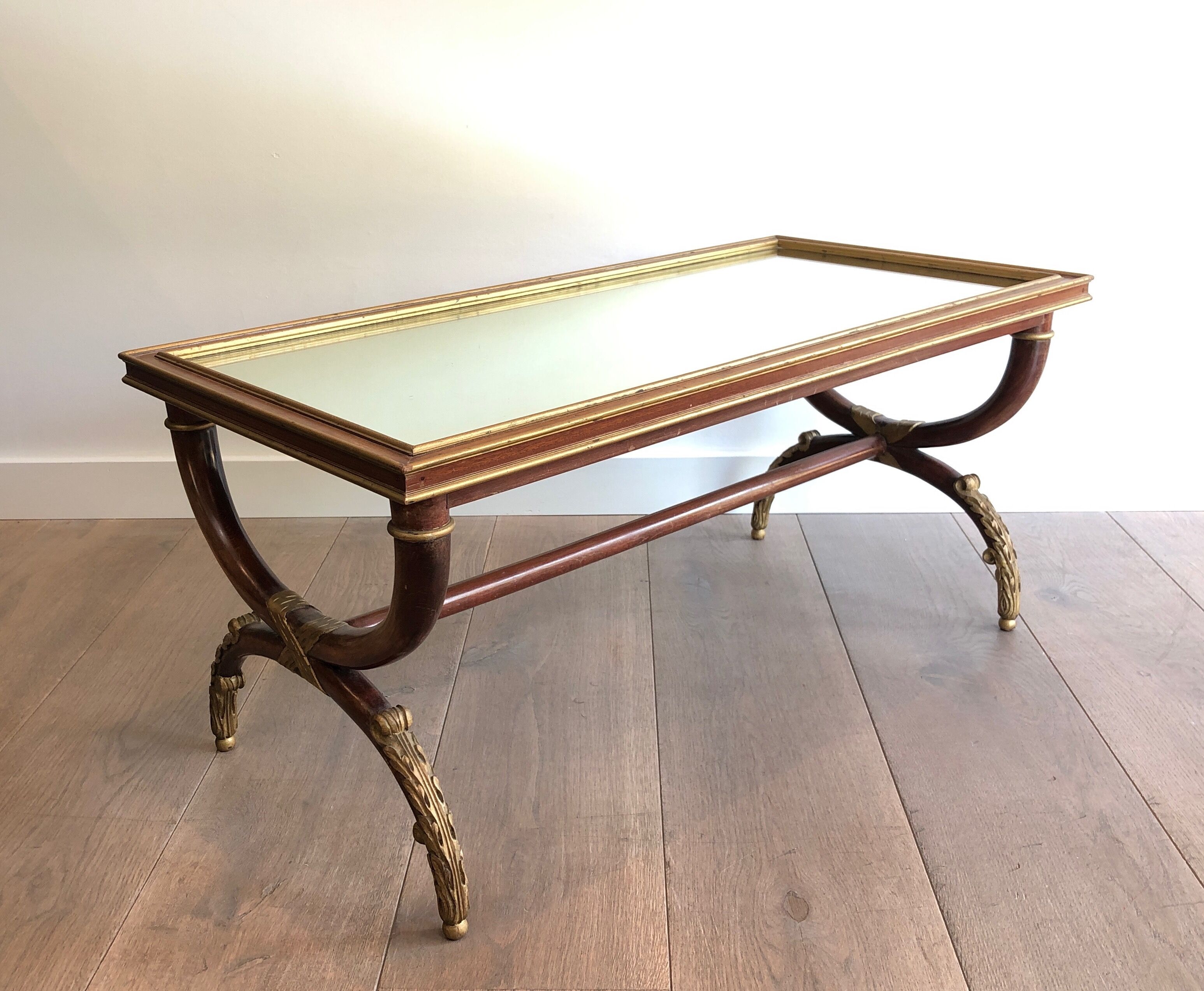 Coffee table in patinated and gilded carved wood with mirror top