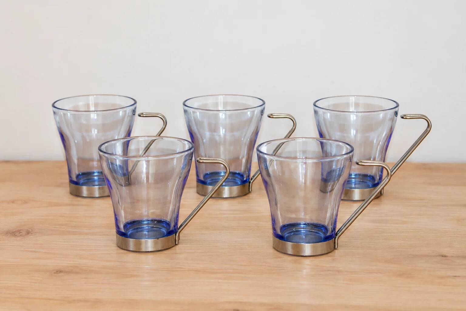 Set of 5 vintage blue-tinted glass cups with metal holders.