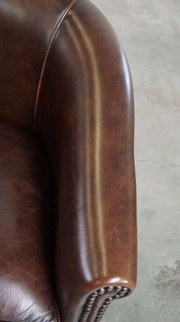fauteuil club de luxe en cuir foncé avec pieds boule de style anglais