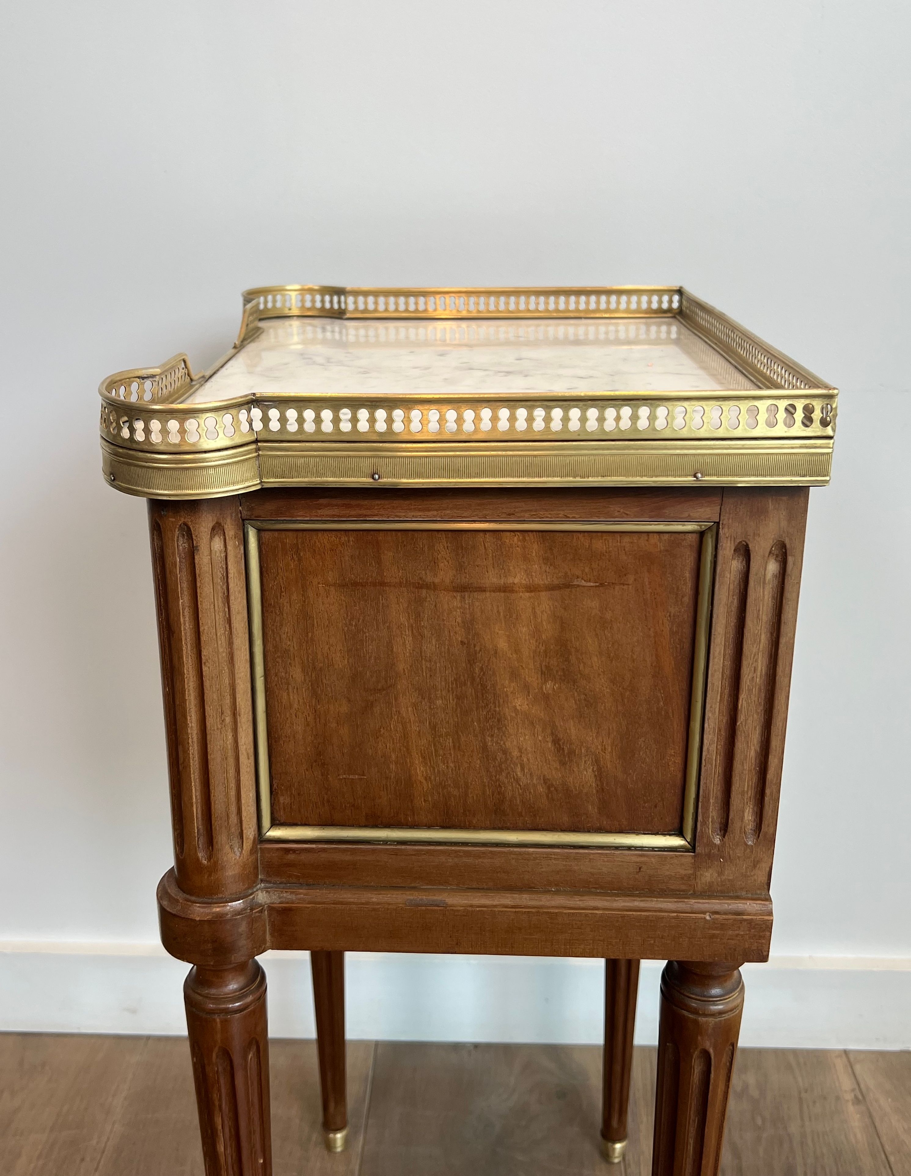 Pair of mahogany and brass side tables or bedside tables with Carrara marble tops.