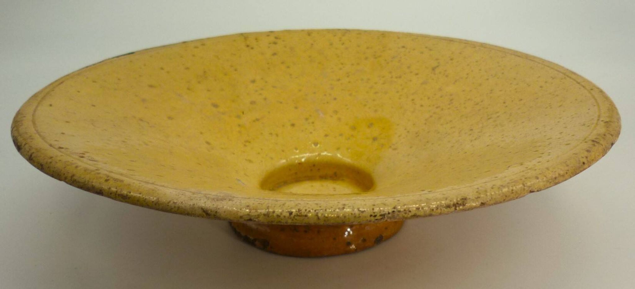 Old omelette turner, glazed yellow terracotta, south of France.