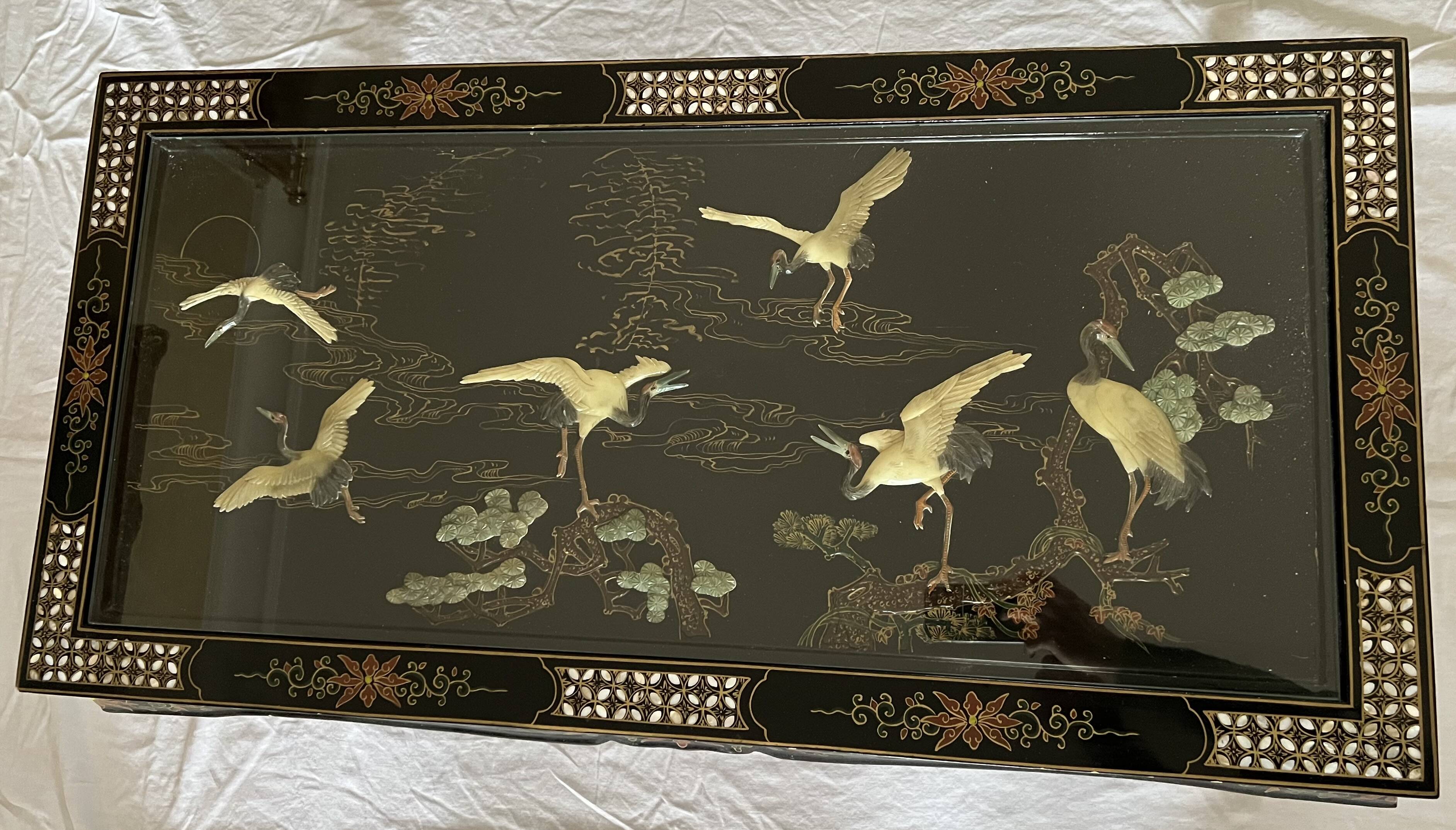 Chinese black wood table inlaid with mother-of-pearl featuring a relief scene of a crane.
