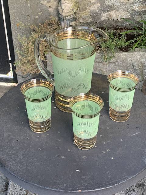 Serve an orangeade, a carafe and 3 glasses in green granite with golden trim.
