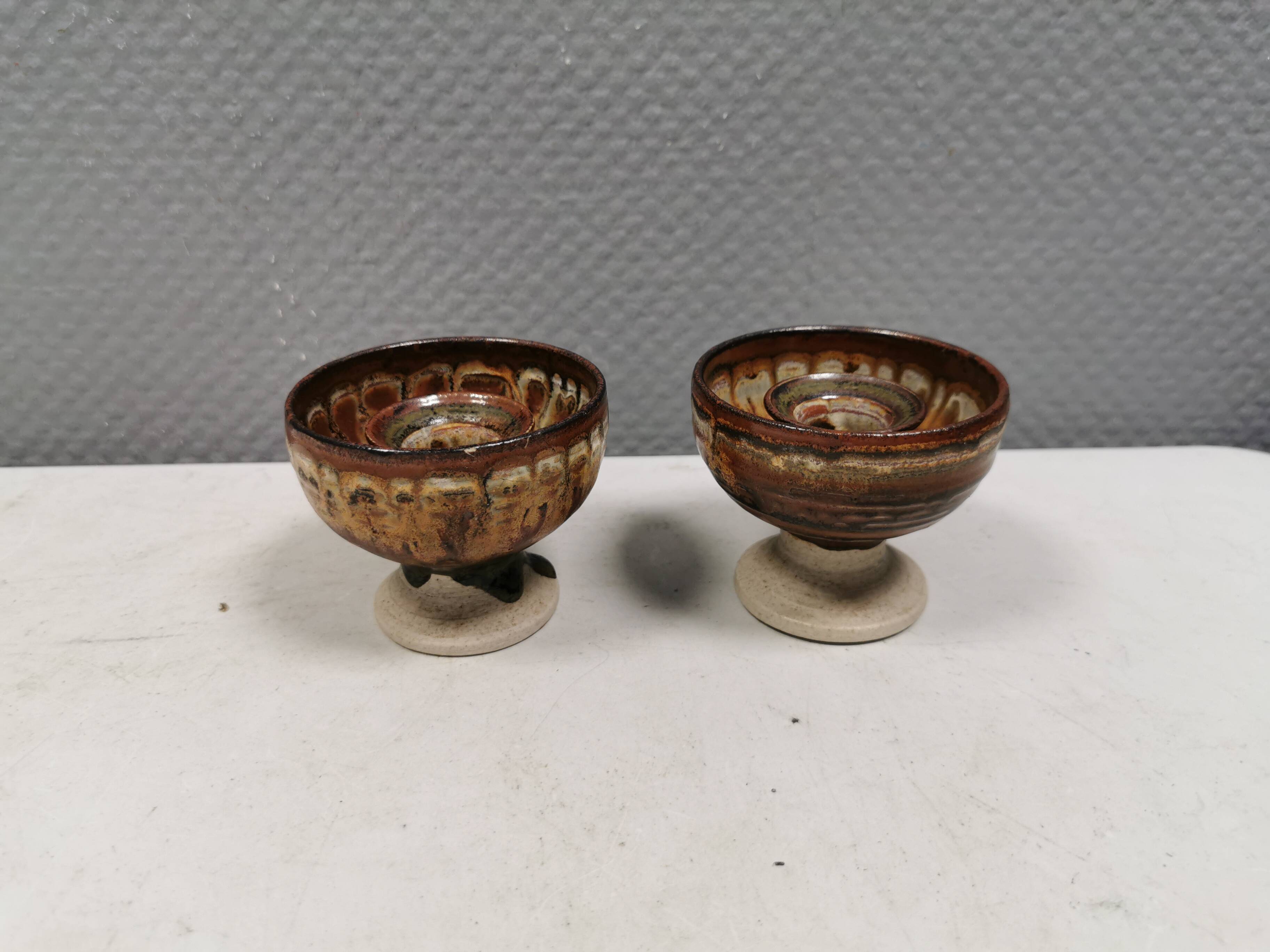 A set of ceramic candle holders in earthy colours.