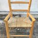 Old wooden children's armchair and vintage woven straw seat