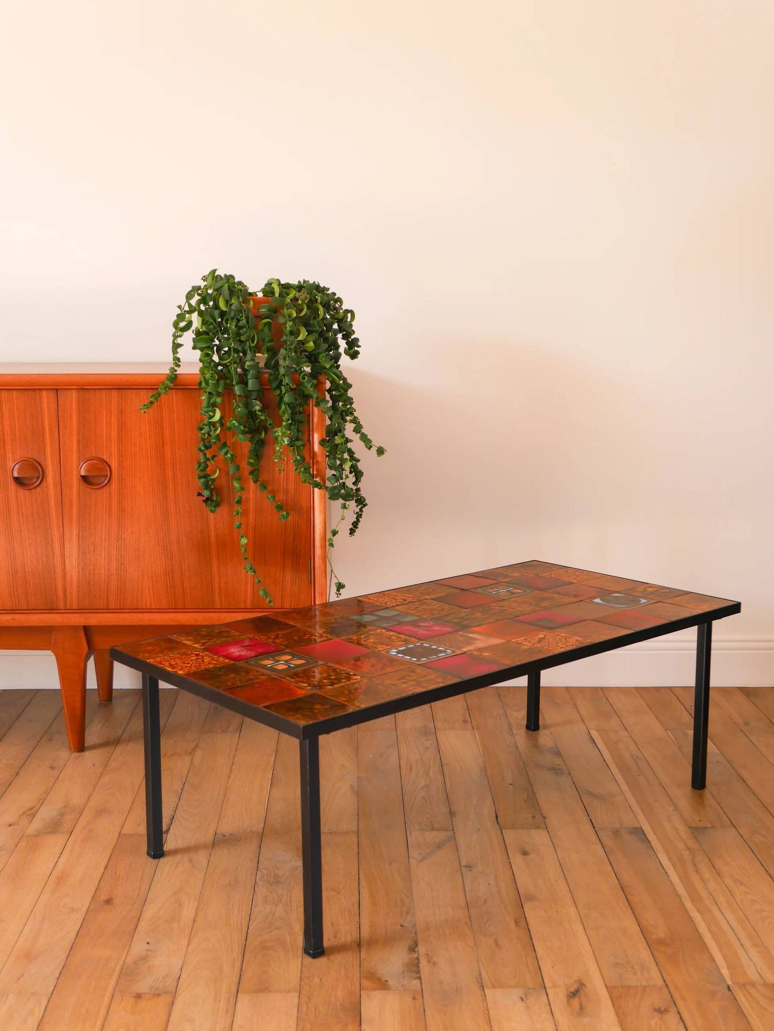Ceramic and black iron coffee table, attributed to the Roche-Bobois brand, with a black metal base and structure, rectangular ceramic top from Vallauris with colourful patterns in ochre and orange, design from the 1970s.