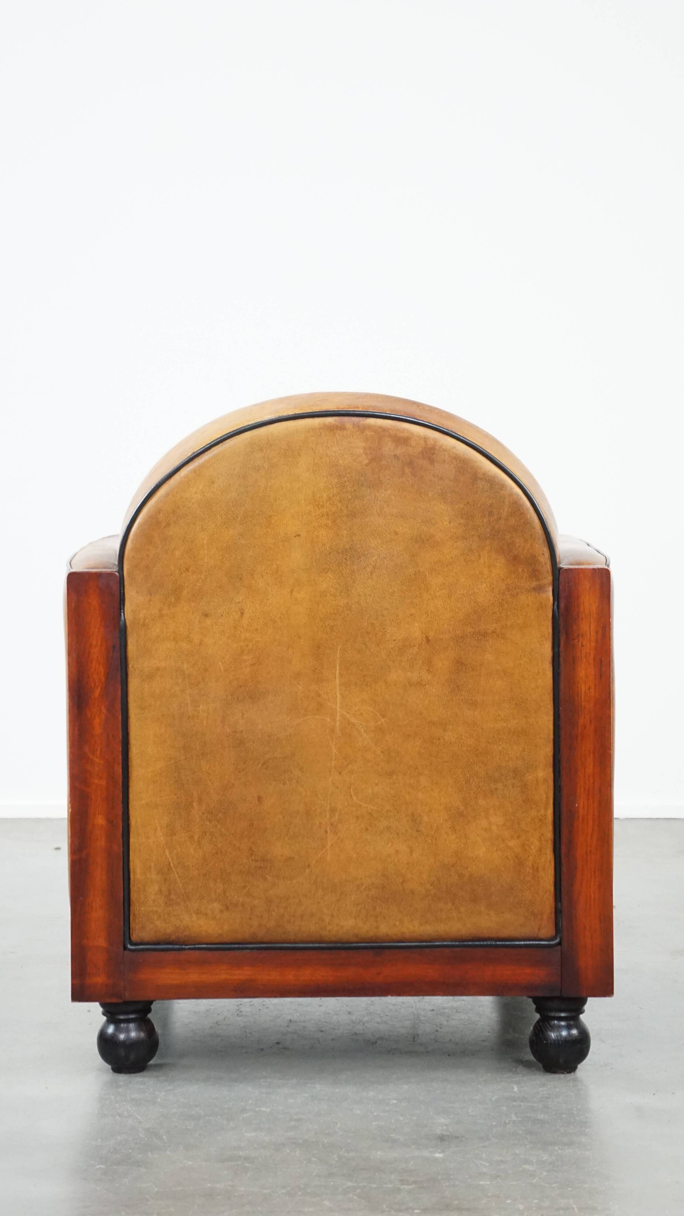 Sheep leather and wooden Art Deco design armchair with ball feet