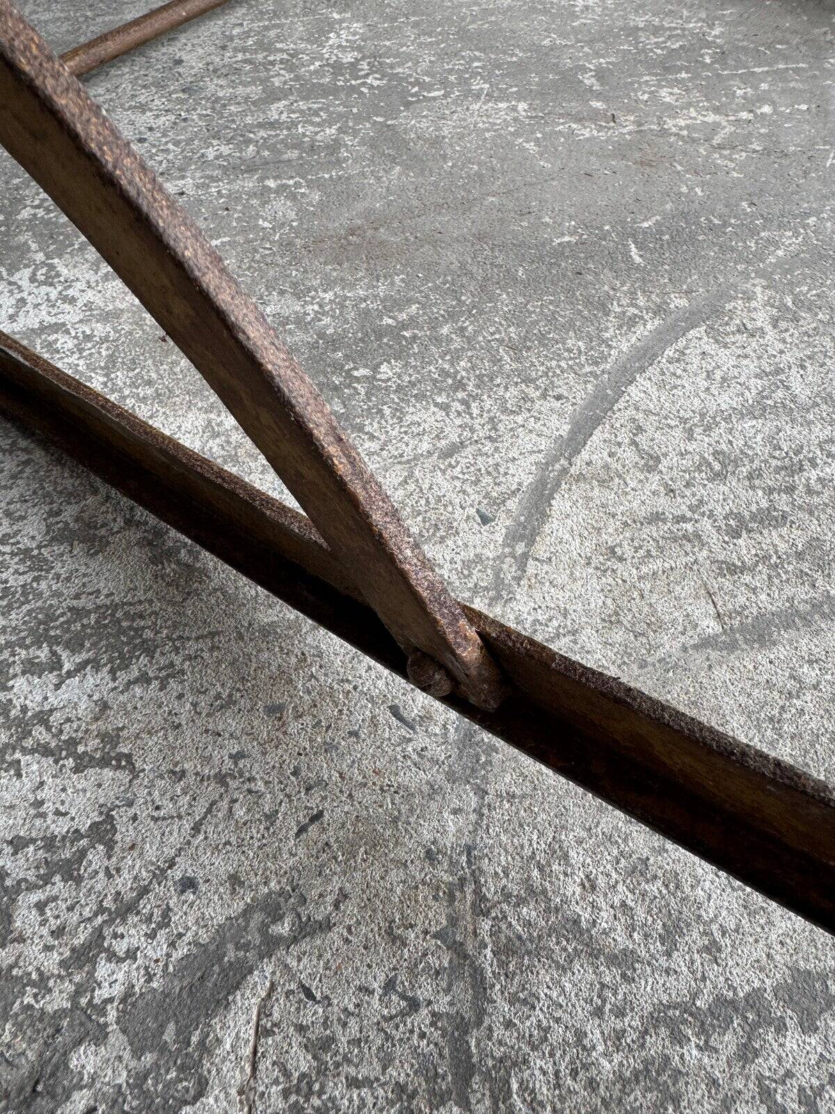 19th-century dark brown wrought-metal rocking chair with cognac leather sling seat, vintage