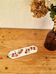 Vintage wall-mounted tea towel holder in enamelled sheet metal with cherry decoration.
