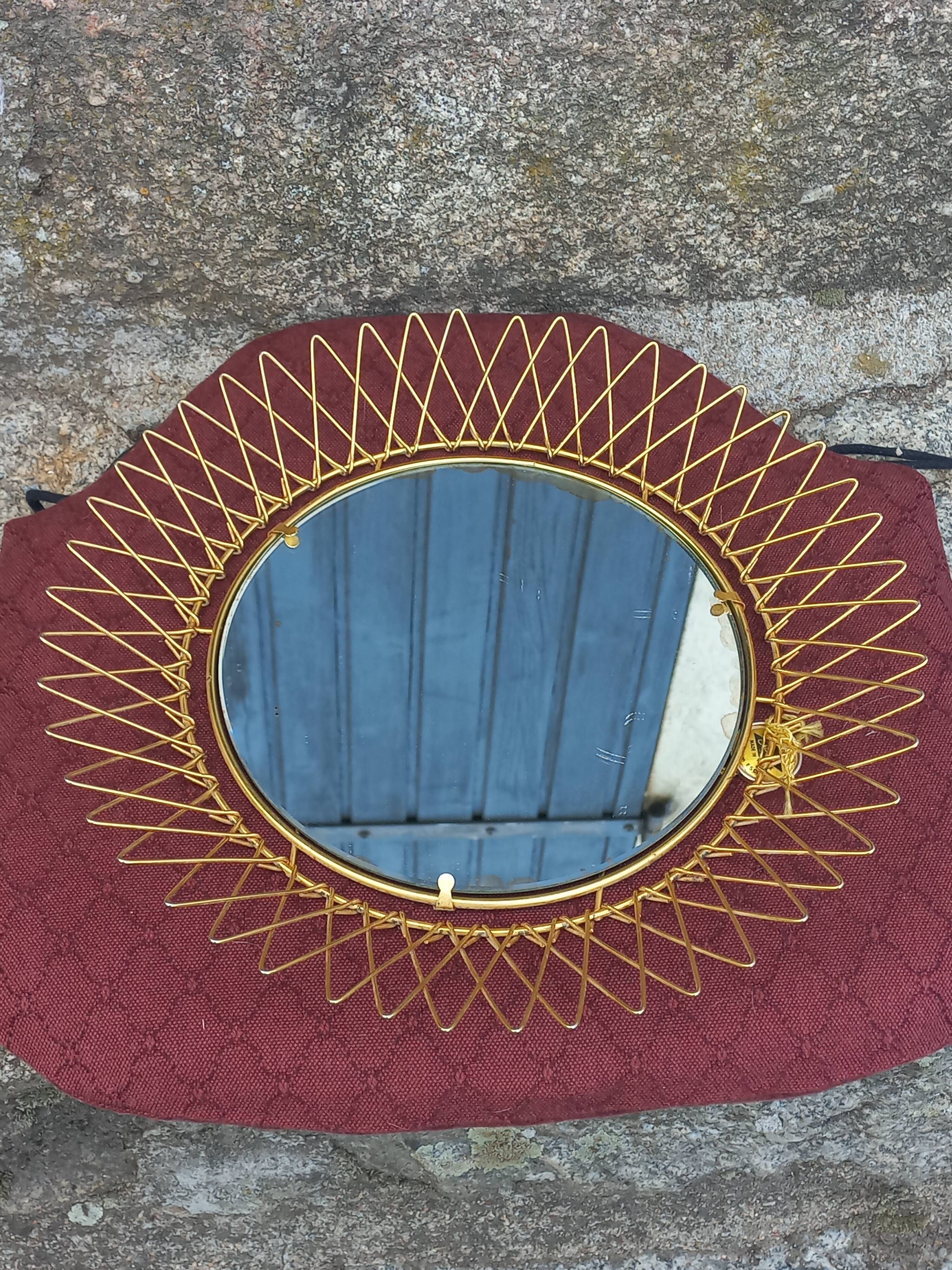 Vintage 1950s sun mirror in gold metal.