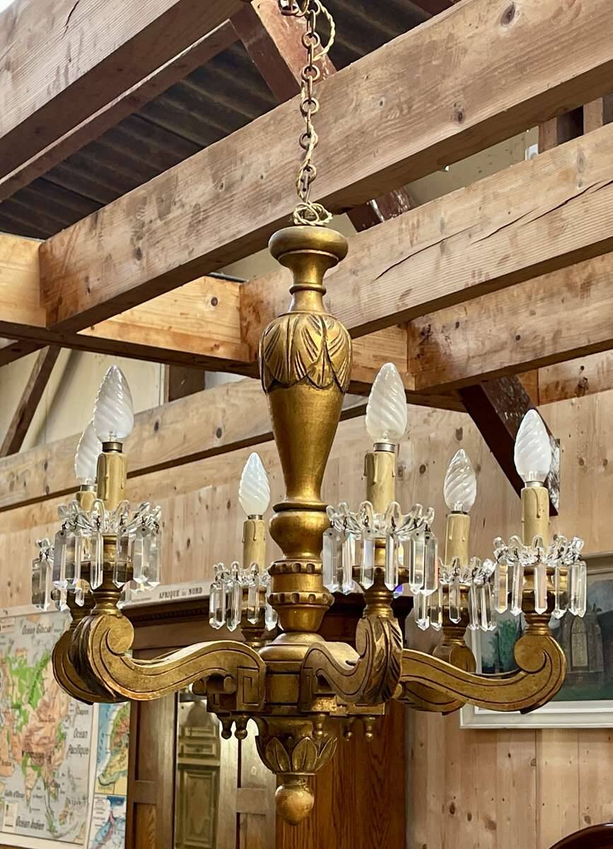 Golden wooden chandelier with crystal pendants from the 19th century.