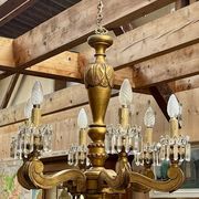 Golden wooden chandelier with crystal pendants from the 19th century.