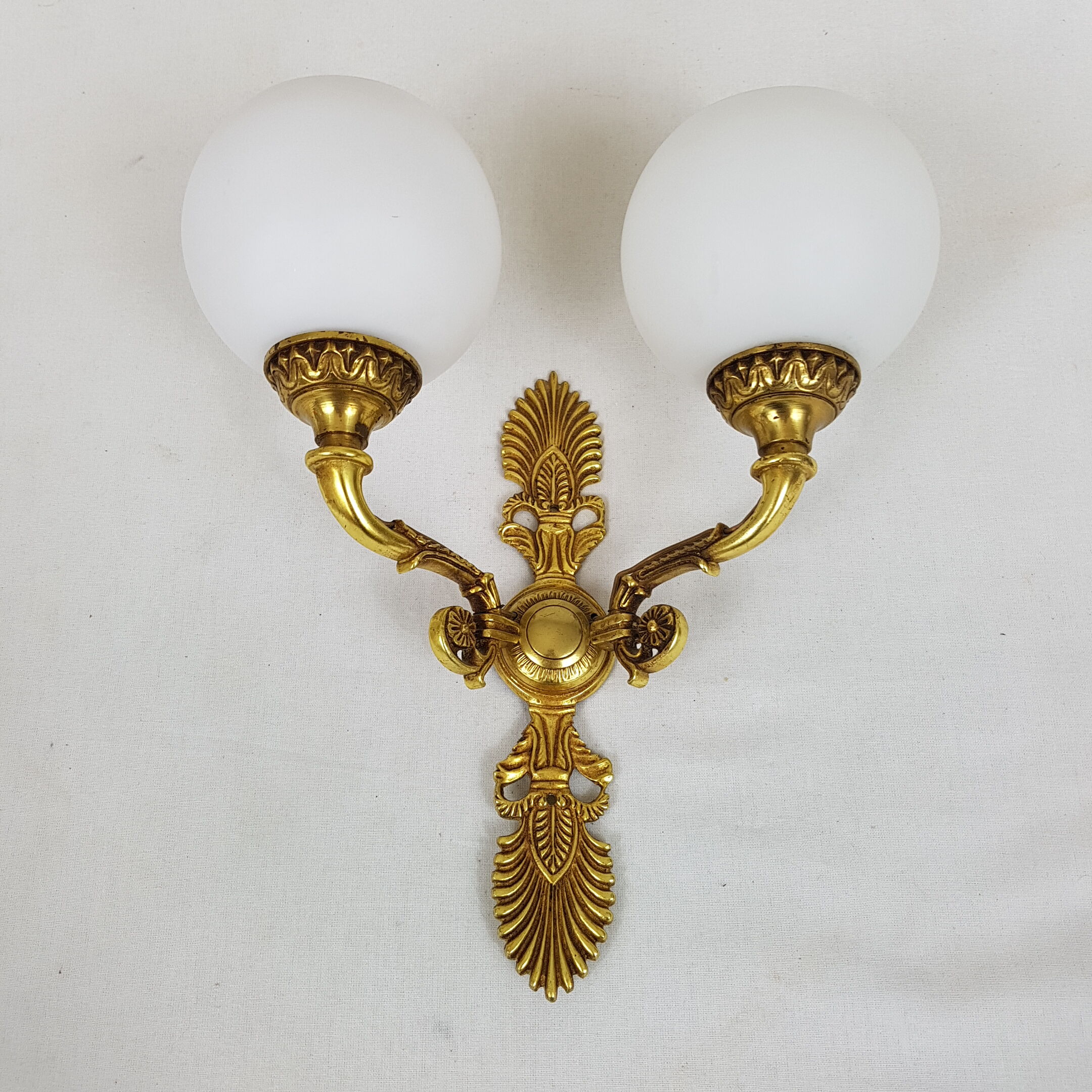 Wall light in gilded bronze and opaque glass globe