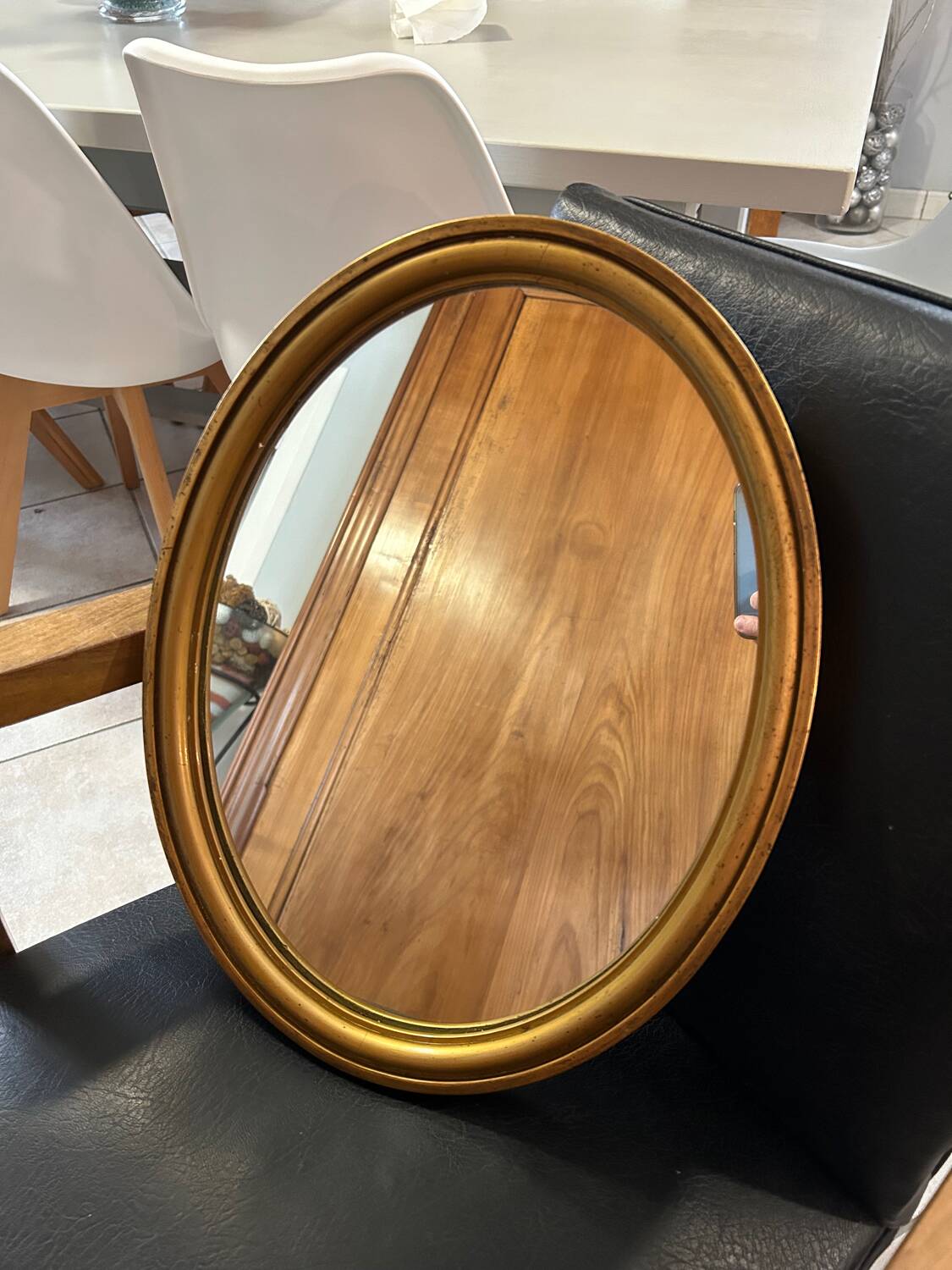Old oval mirror in gilded wood from the 20th century