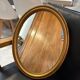 Old oval mirror in gilded wood from the 20th century