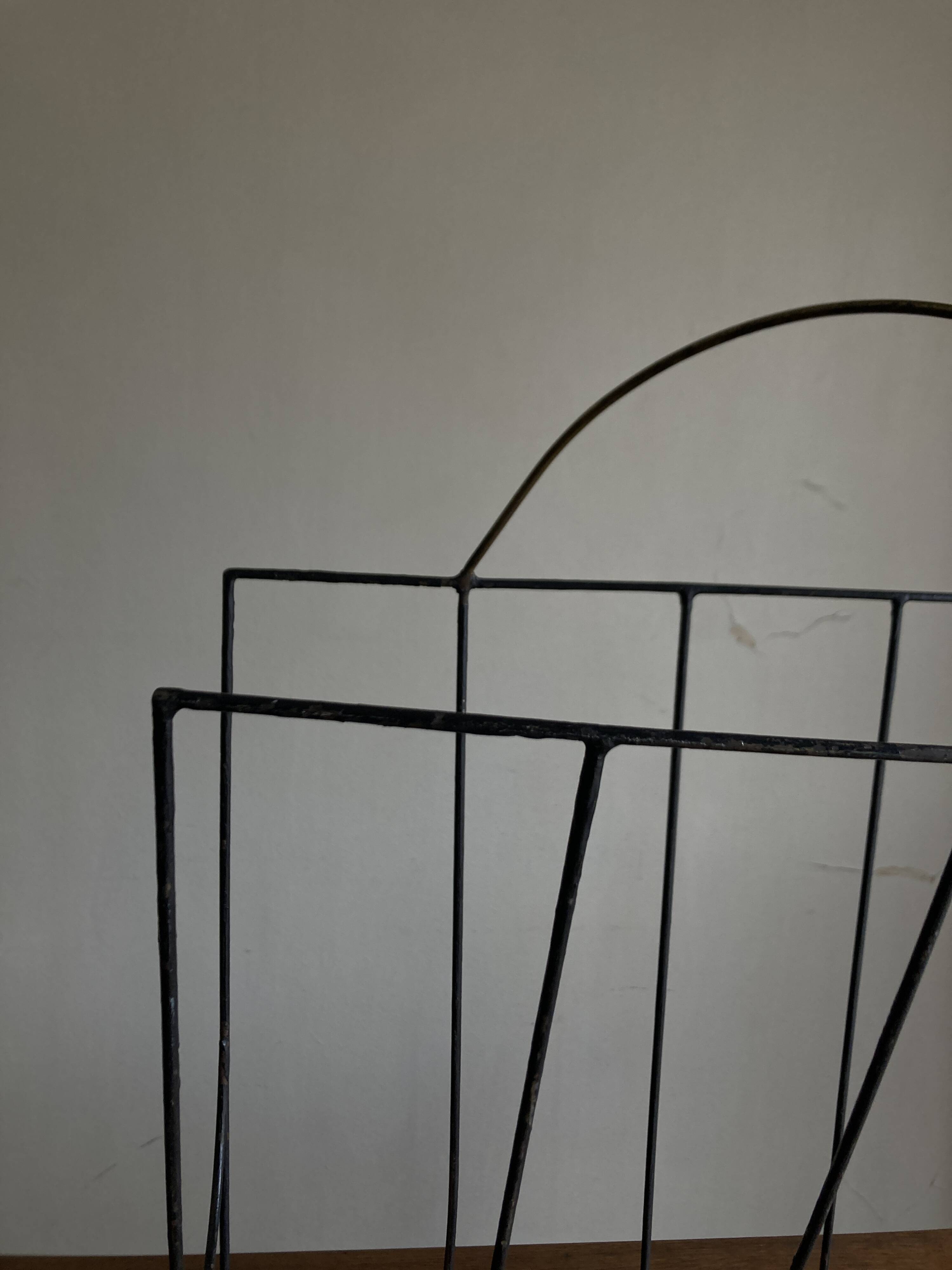 Mid-century poetic magazine rack in black metal